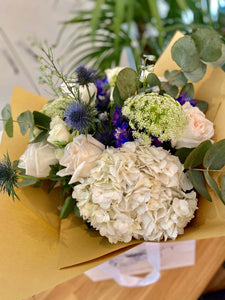 Aimee bouquet by Margot Floral Design. A fresh flower bouquet composed of White O'Hara Garden Roses, Blue Delphiniums, White Bouvardias, and Eucalyptus. Large size.