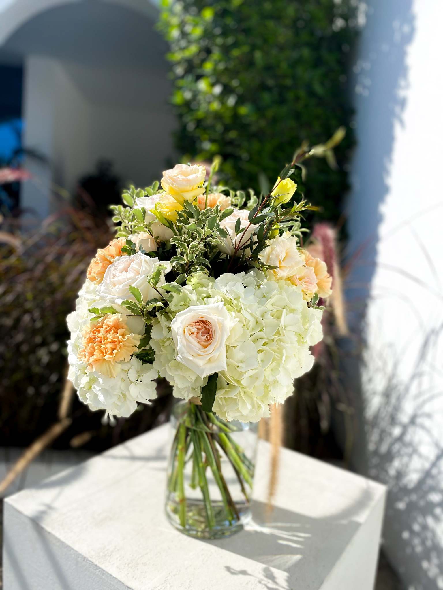 Gabriella bouquet by Margot Floral Design. A fresh flower bouquet composed of Pink Roses, White Hydrangeas, Orange and Yellow Carnations. Medium size.