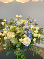 Load image into Gallery viewer, Josephine bouquet by Margot Floral Design. A fresh flower bouquet composed of White O&#39;Hara Garden Roses, Blue Delphinium, Eryngium, and Eucalyptus. Medium size.
