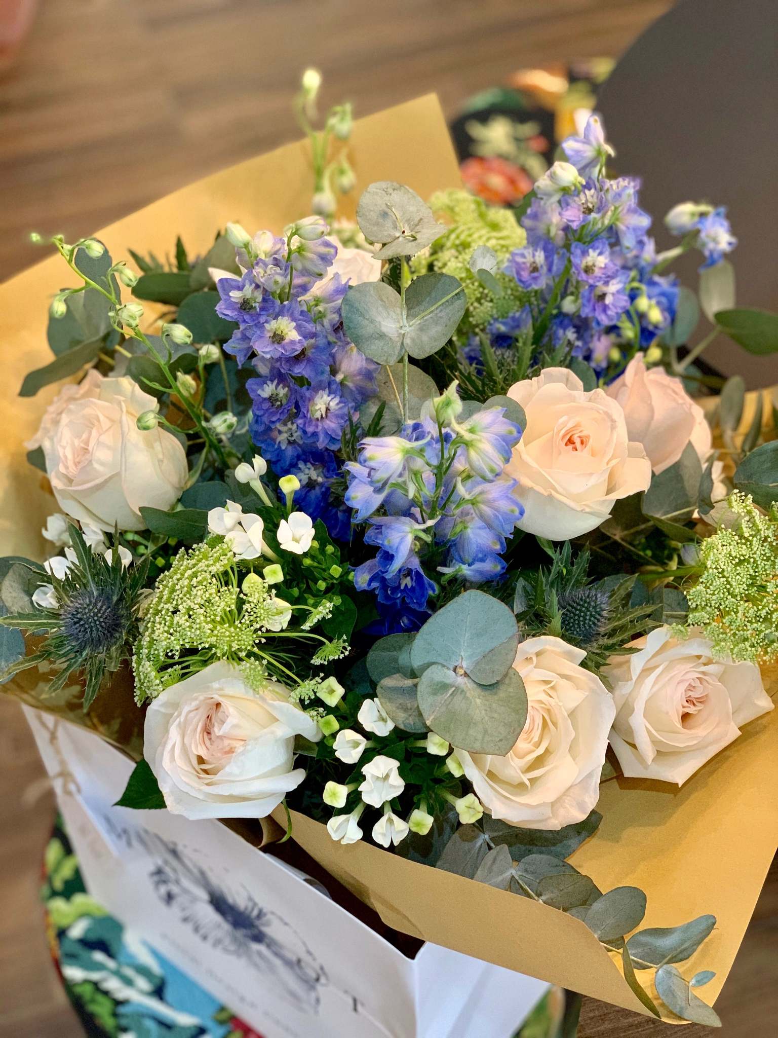Margot bouquet by Margot Floral Design. A fresh flower bouquet composed of White O'Hara Garden Roses, Blue Delphinium, White Bouvardia, Ammi, and Eucalyptus.