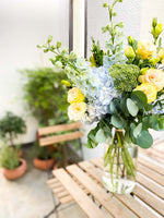 Load image into Gallery viewer, Valentine bouquet by Margot Floral Design. A fresh flower bouquet composed of Pale Yellow Roses, White Delphinium, Blue Hydrangea, and Eucalyptus. Medium Size.
